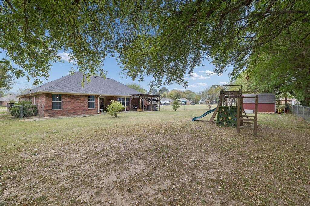 25 Starview Drive, Star Harbor, TX 75148 Fenced backyard with a playground, a storage unit, a patio, and a gazebo