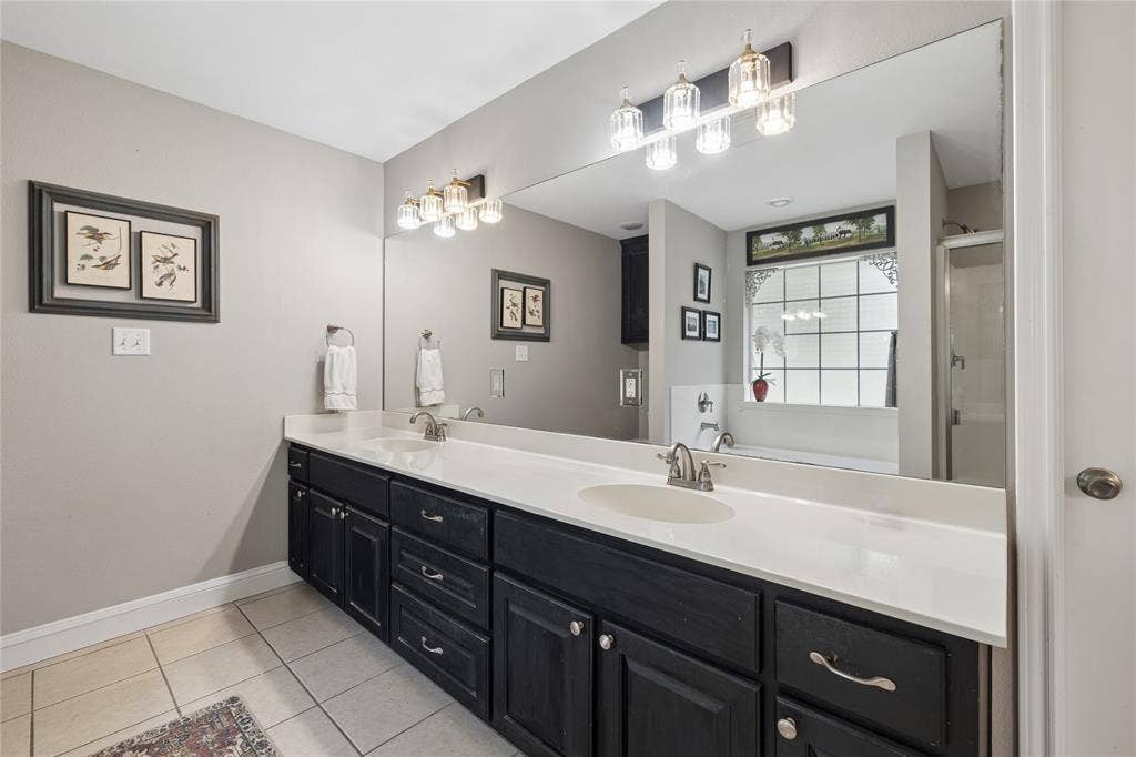 25 Starview Drive, Star Harbor, TX 75148 Bathroom featuring double vanity, a shower stall, and light tile patterned flooring
