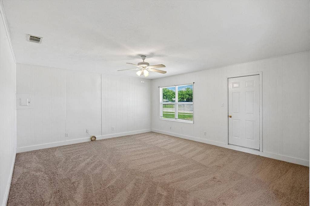 5820 Shipp Drive, Watauga, TX 76148 Spacious room featuring new carpeting, white paneled walls, a ceiling fan with integrated lighting, and a single window offering natural light