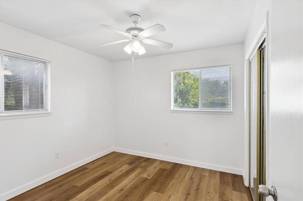 5820 Shipp Drive, Watauga, TX 76148 Bright room featuring wood-finish flooring, white walls, and a ceiling fan with integrated lighting
