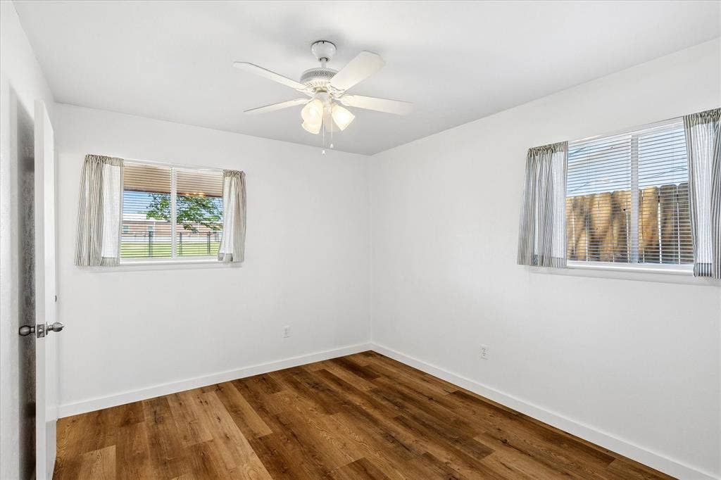 5820 Shipp Drive, Watauga, TX 76148 Room featuring wood-finish flooring, white walls, and a ceiling fan with integrated lighting