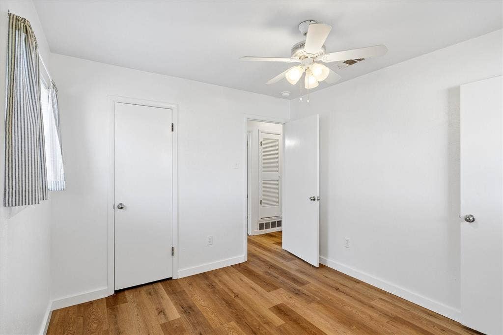 5820 Shipp Drive, Watauga, TX 76148 Room featuring wood-finish flooring, white walls, and a ceiling fan with integrated lighting