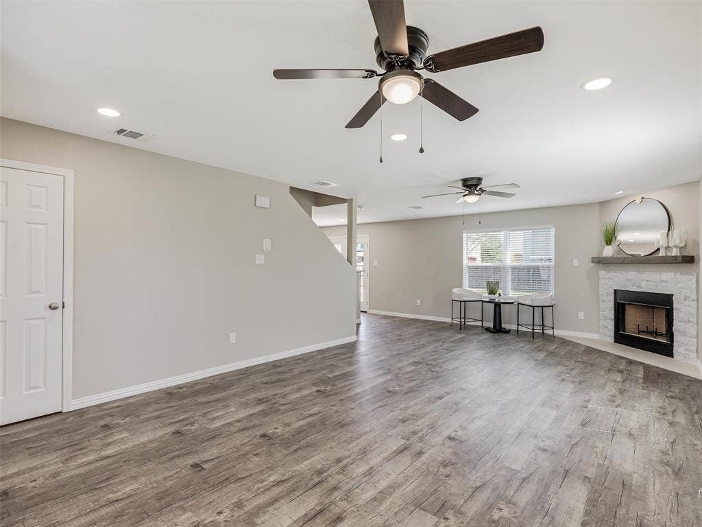 Spacious living area featuring wood-finish flooring, recessed lighting, and ceiling fans
