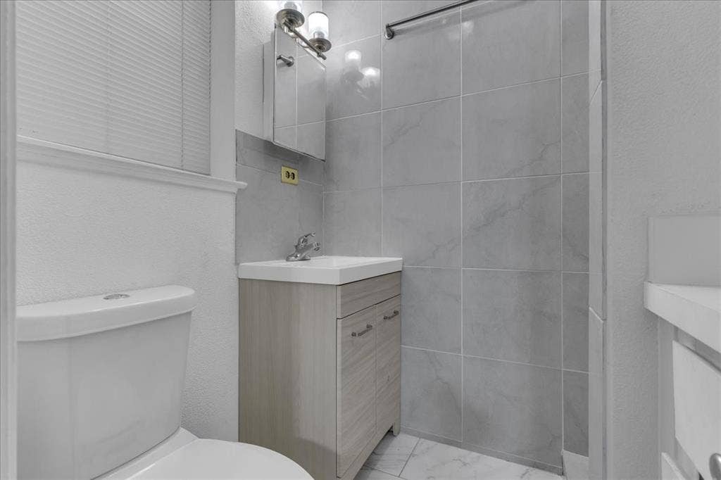905 SE 3rd Street, Grand Prairie, TX 75051 Bathroom featuring vanity and a textured wall