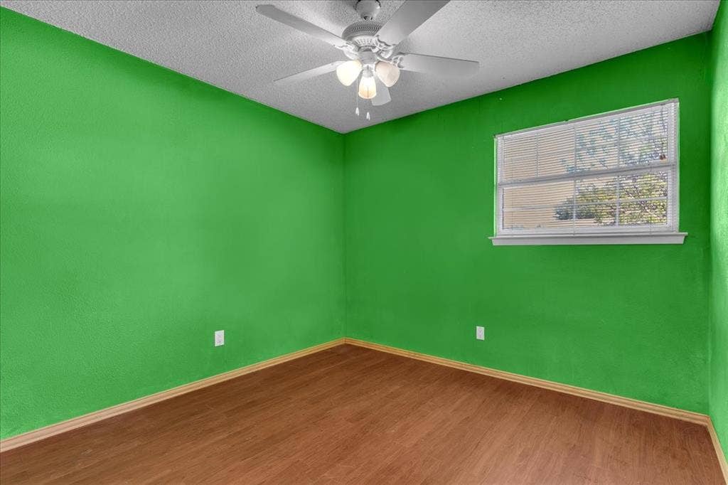 905 SE 3rd Street, Grand Prairie, TX 75051 Unfurnished room featuring ceiling fan, dark wood-style flooring, and a textured ceiling