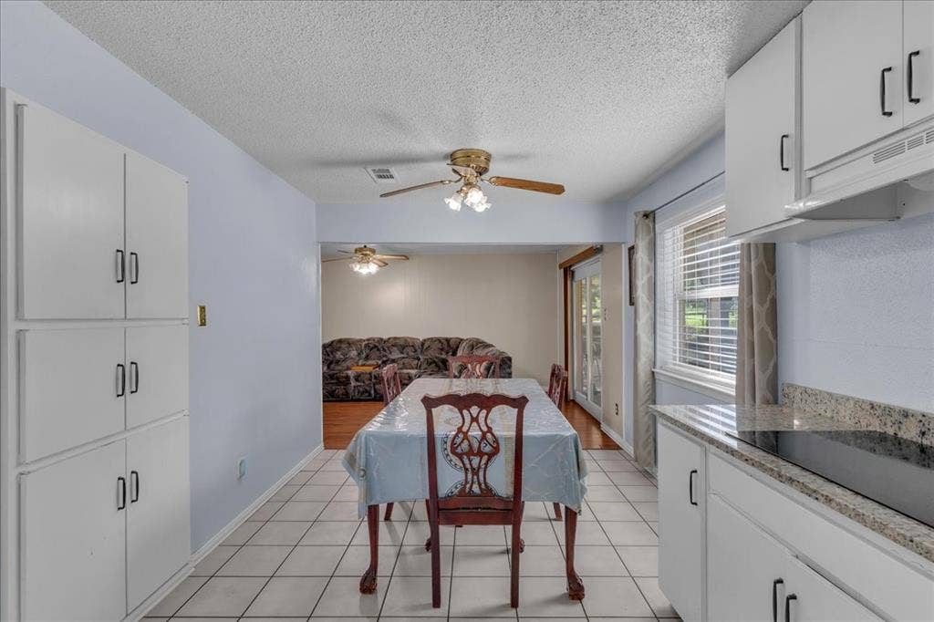 905 SE 3rd Street, Grand Prairie, TX 75051 Dining area featuring a textured ceiling, light tile patterned floors, and a ceiling fan