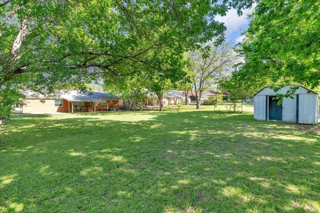 905 SE 3rd Street, Grand Prairie, TX 75051 Fenced backyard featuring a shed