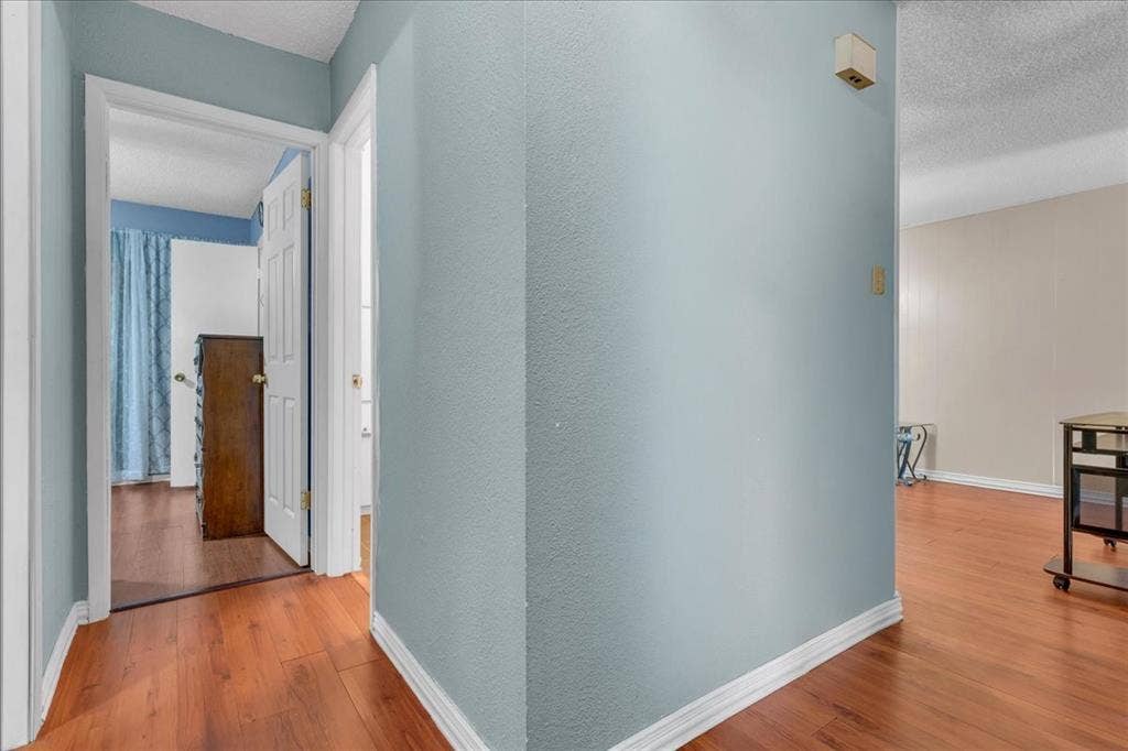 905 SE 3rd Street, Grand Prairie, TX 75051 Hall featuring light wood-style flooring and a textured ceiling