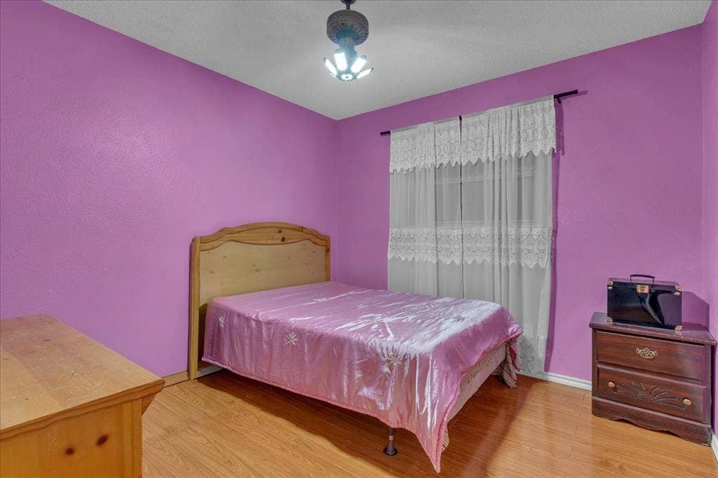 905 SE 3rd Street, Grand Prairie, TX 75051 Bedroom with light wood-style flooring and baseboards