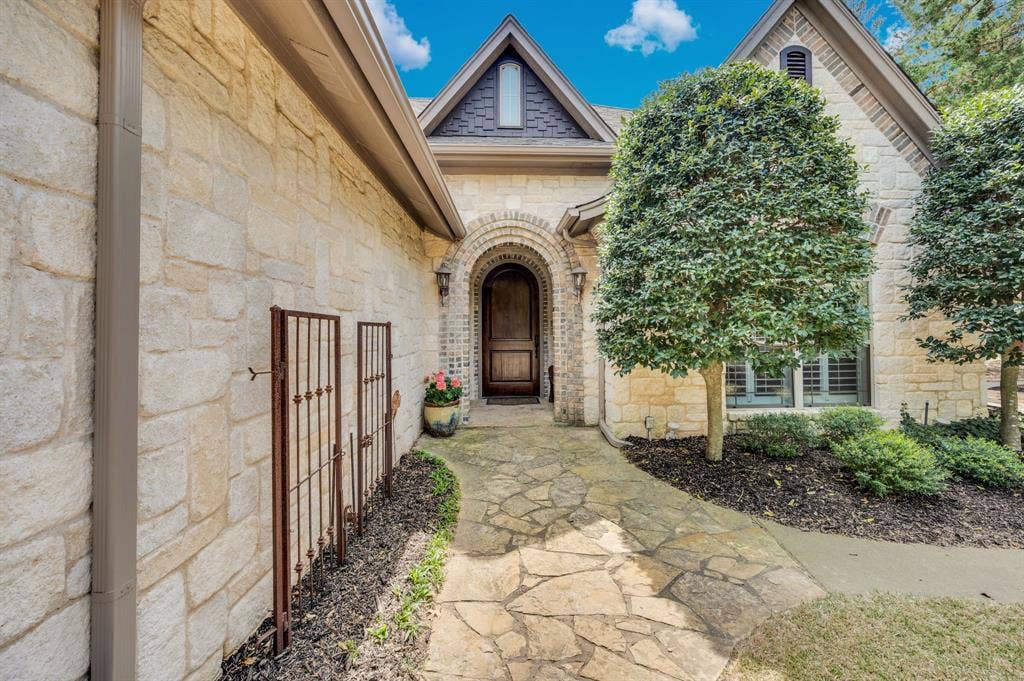 Arched entry with custom wood front door and stone detail