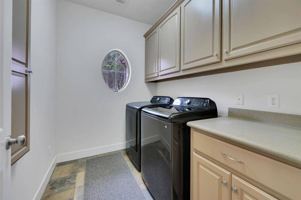 Utility room with built-in cabinets, counter space, and washer and dryer area.