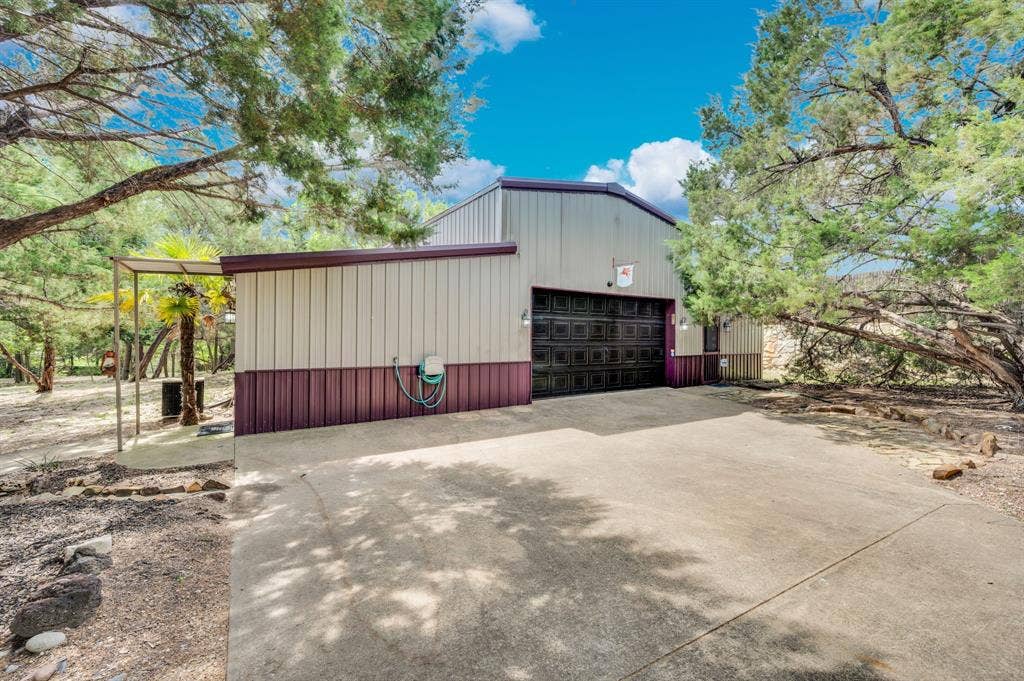 Exterior of workshop with large overhead door and concrete drive access