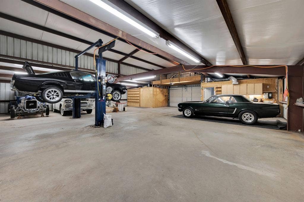 Additional view of workshop featuring multiple parking spaces and storage.