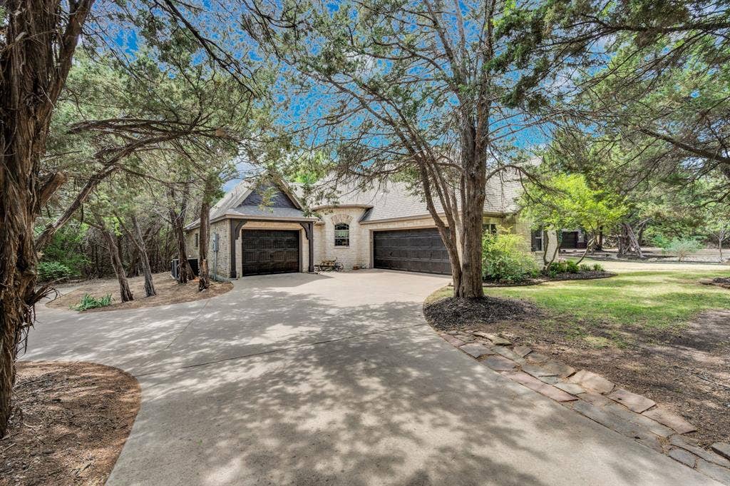 Side view of home with spacious driveway and additional garage space