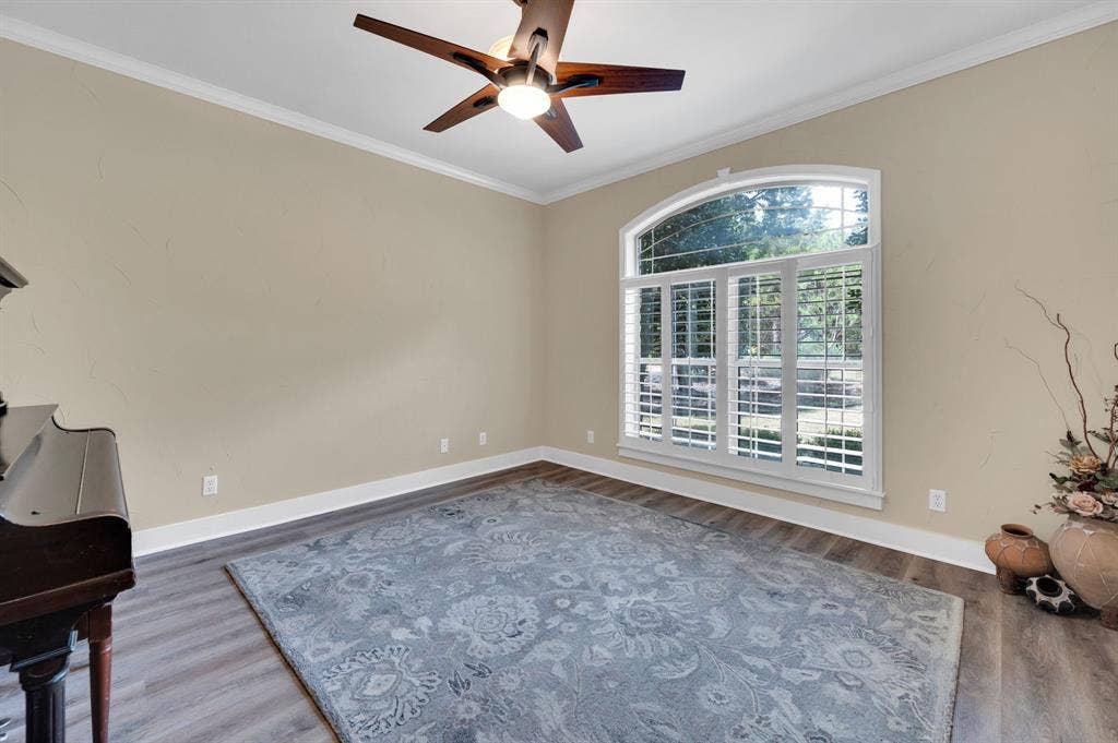 Flex living space or formal room with large arched window and abundant natural light.