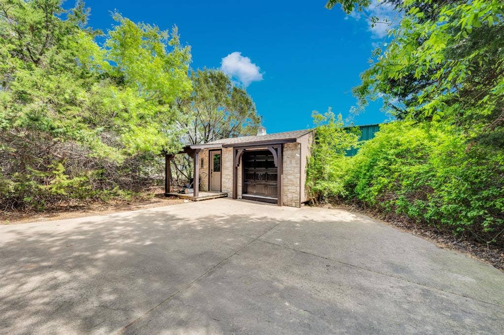 Private driveway leading to detached storage surrounded by trees