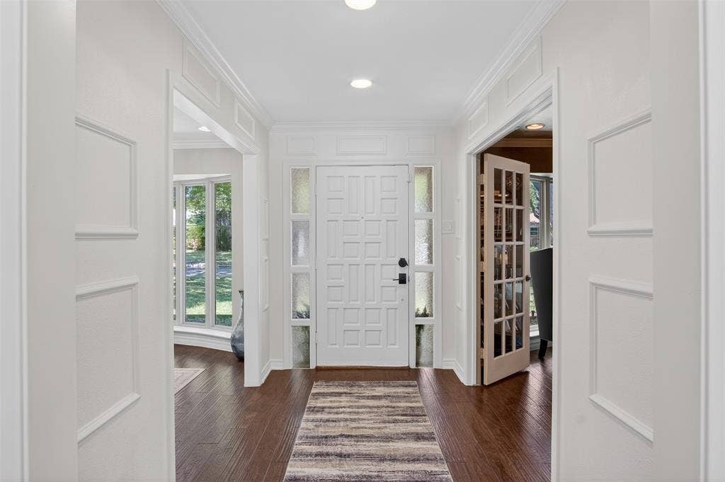 Entrance foyer with dark wood-style flooring, crown molding, and recessed lighting