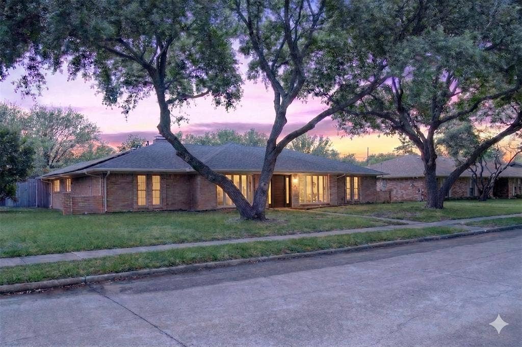 Ranch-style home featuring a yard and brick siding