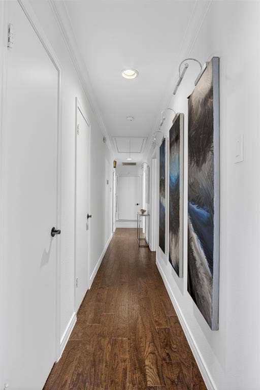 Corridor with ornamental molding, dark wood finished floors, and recessed lighting