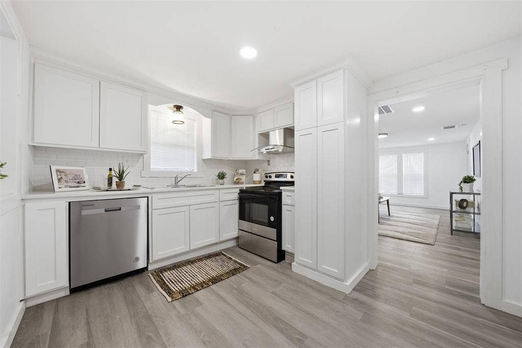 1116 Houston Street, Waco, TX 76704 Kitchen with stainless steel appliances, white cabinets, light countertops, light wood finished floors, and recessed lighting