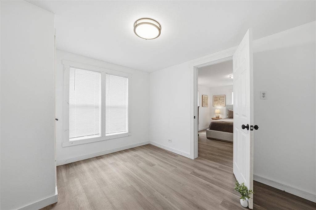 1116 Houston Street, Waco, TX 76704 Spare room featuring baseboards and light wood-style floors