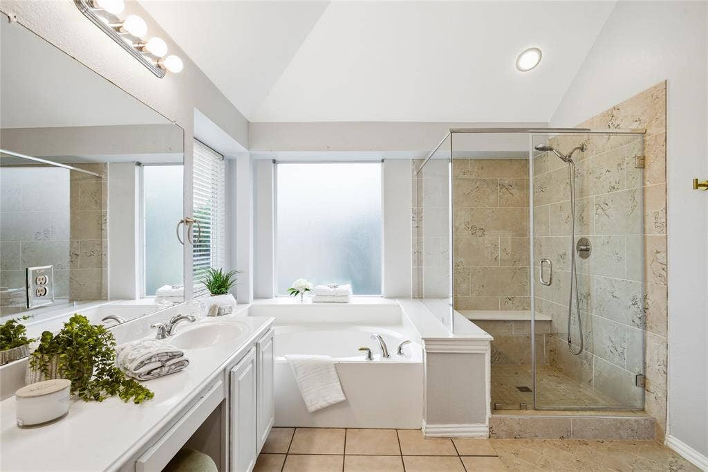 5201 Geode Lane, McKinney, TX 75072 View of primary bath with garden tub, separate step in shower and double sink vanity.