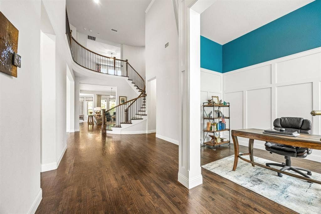 Just inside the front door, there is a flex space currently being used as an office.  It features an elegant two-tone wall featuring the classic board and batten pattern adding architectural depth and structure to the space. Other uses could include a formal living or music room featuring a baby grand piano.