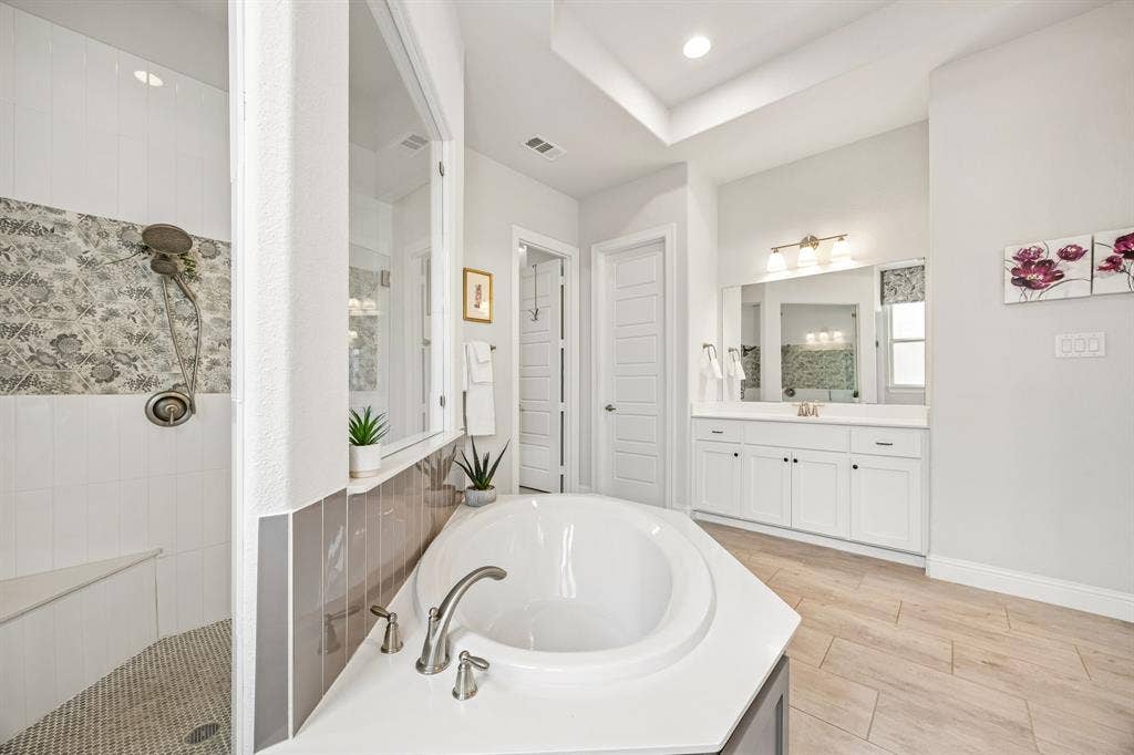 This spacious primary ensuite offers dual vanities set across the space from one another.