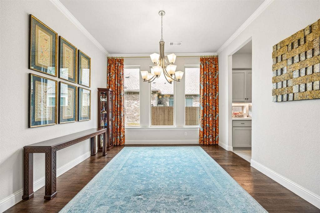 The rich hardwood flooring extends into the formal dining room. A wall of windows anchors the room and floods the space with natural light.