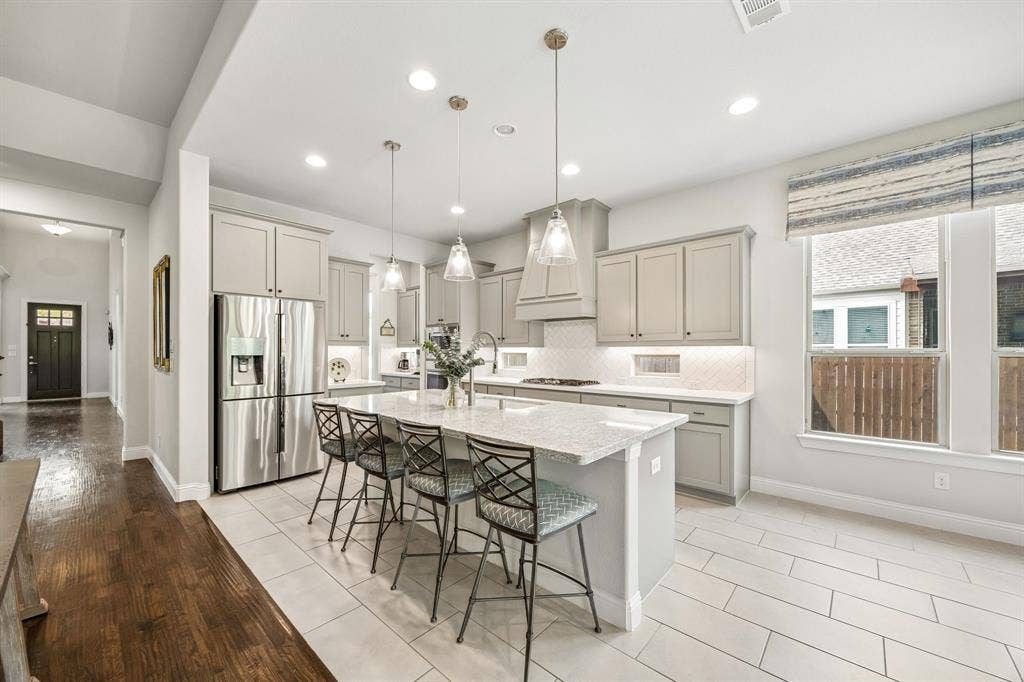 Spectacular chef's kitchen, designed for both high-end culinary creation and effortless entertaining. A bright and airy space centers around a massive quartz island that comfortably seats four, making it the ultimate gathering hub for family and guests.
