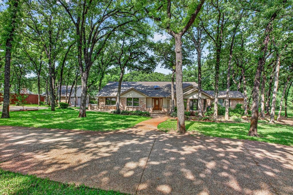 1607 N Main Street, Euless, TX 76039 The property features a stone and brick exterior, a front entry with a wooden door, and a brown roof