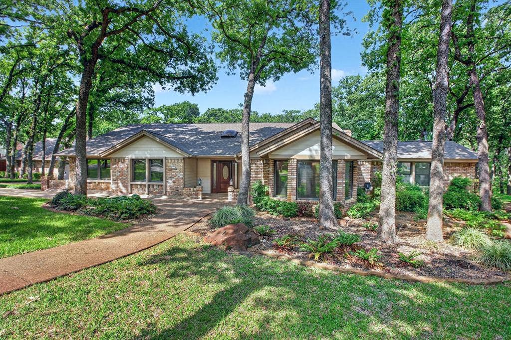 1607 N Main Street, Euless, TX 76039 The property features an extensive lawn, mature trees, and a pathway leading to the front entrance