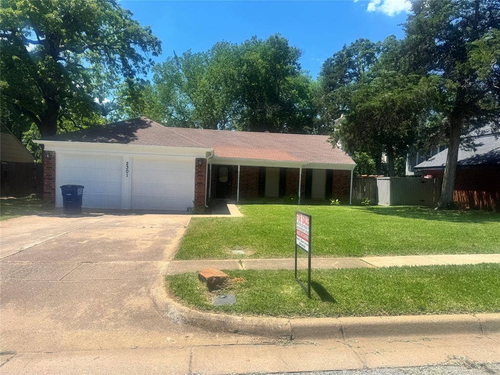 2301 Holly Drive, Euless, TX 76039 Ranch-style residence featuring a brick facade and a two-car garage