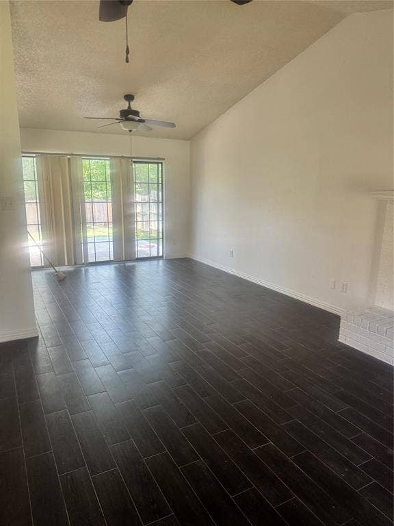 2301 Holly Drive, Euless, TX 76039 Spacious room featuring dark wood-finish flooring, vaulted ceilings, and large windows with vertical blinds