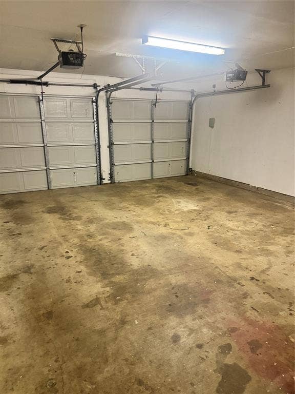 2301 Holly Drive, Euless, TX 76039 Two-car garage featuring panel-style garage doors with automatic openers and overhead fluorescent lighting