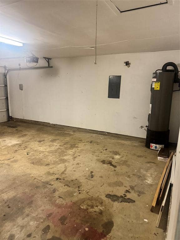 2301 Holly Drive, Euless, TX 76039 Attached garage space featuring a concrete floor, white walls, and an overhead garage door