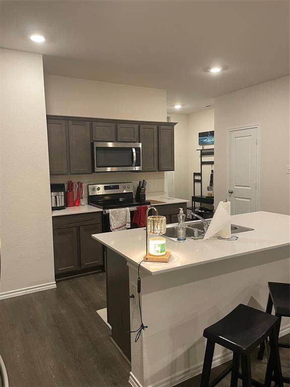 468 Unbridled Road, Waxahachie, TX 75165 Kitchen with a breakfast bar area, stainless steel appliances, dark wood finished floors, a kitchen island with sink, and recessed lighting