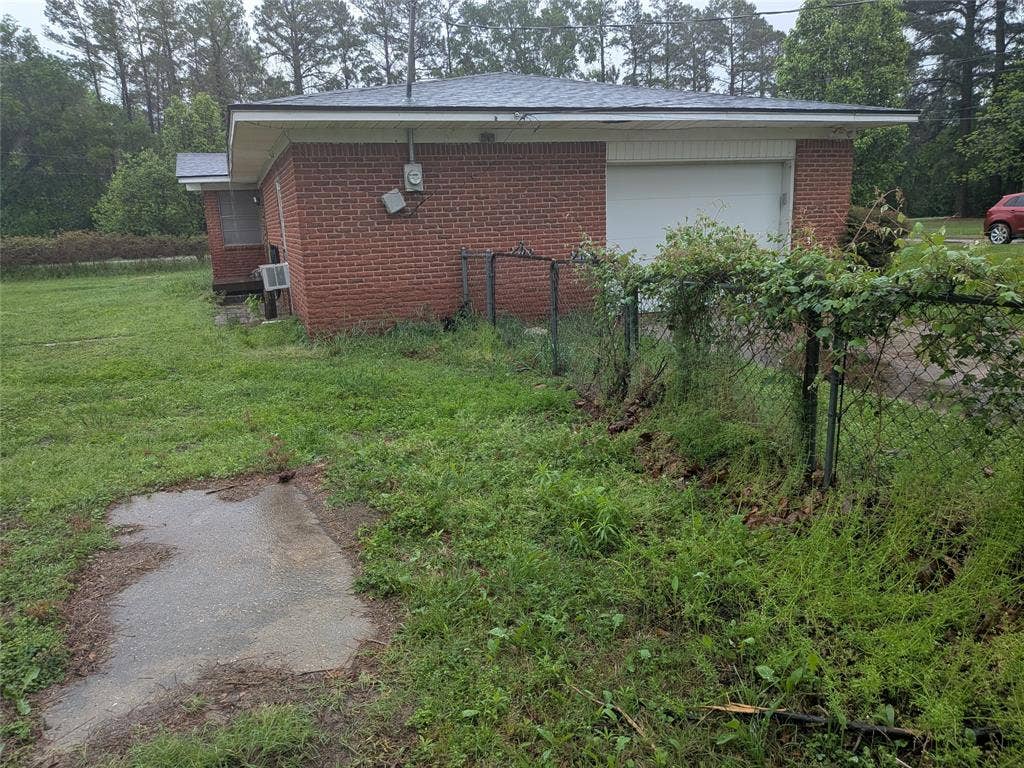 2009 County Road 4619, Athens, TX 75752 View of side of property with brick siding and an attached garage