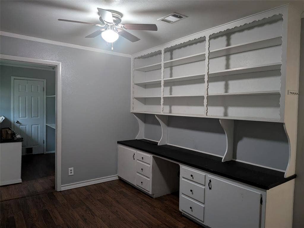 2009 County Road 4619, Athens, TX 75752 Unfurnished office featuring a ceiling fan, dark wood-style flooring, crown molding, and built in desk