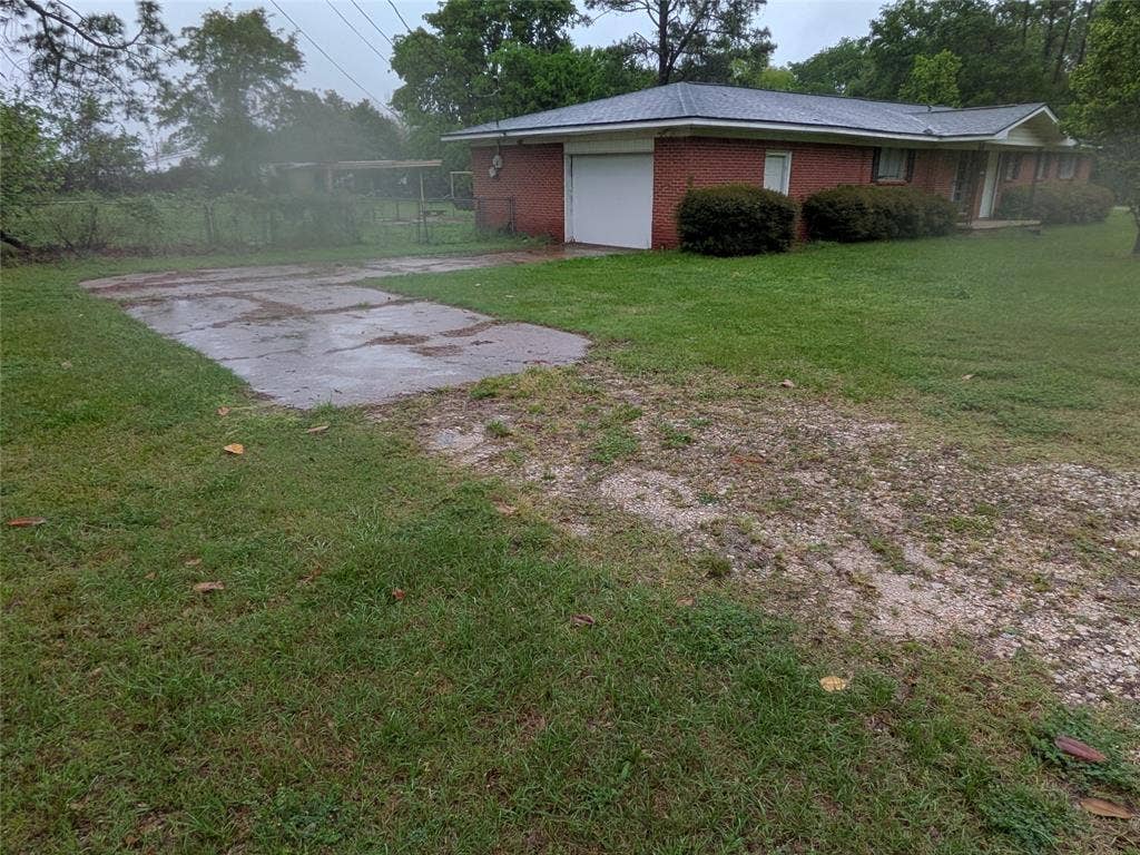 2009 County Road 4619, Athens, TX 75752 Single story home with brick siding, a garage, and a front lawn