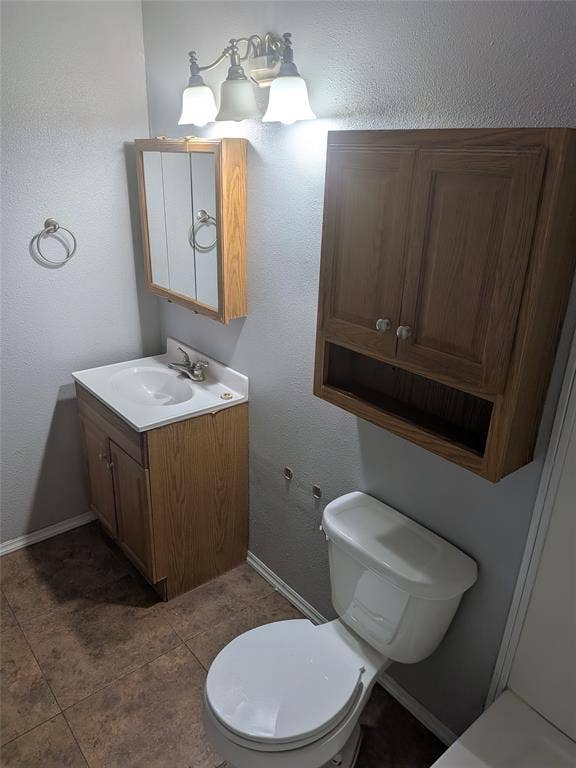 2009 County Road 4619, Athens, TX 75752 Bathroom with vanity, a textured wall, and dark tile patterned floors