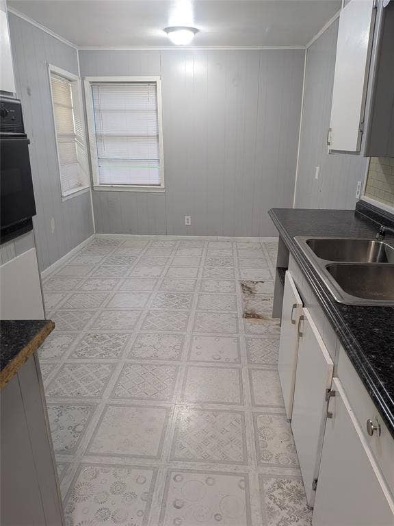 2009 County Road 4619, Athens, TX 75752 Kitchen with dark countertops, white cabinetry, wooden walls, light floors, and oven