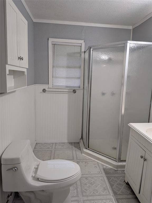 2009 County Road 4619, Athens, TX 75752 Bathroom with vanity, a stall shower, ornamental molding, a wainscoted wall, and a textured ceiling