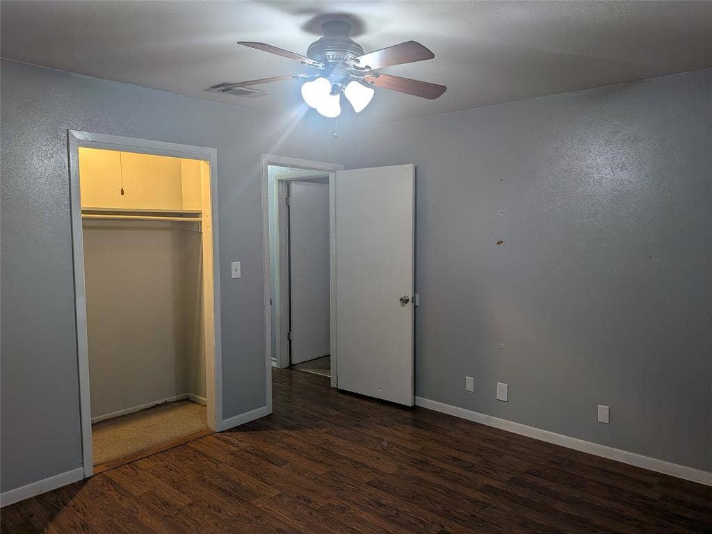 2009 County Road 4619, Athens, TX 75752 Unfurnished bedroom featuring dark wood-type flooring, a ceiling fan, and a closet