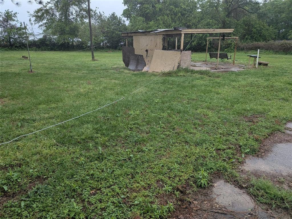 2009 County Road 4619, Athens, TX 75752 View of grassy yard featuring an outbuilding, view of wooded area, and a patio