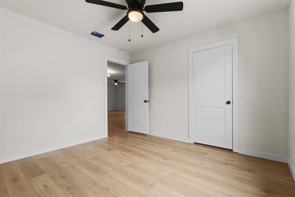 425 Browning Drive, Arlington, TX 76010 Bright room featuring wood-finish flooring, crisp white walls, and a ceiling fan with integrated lighting