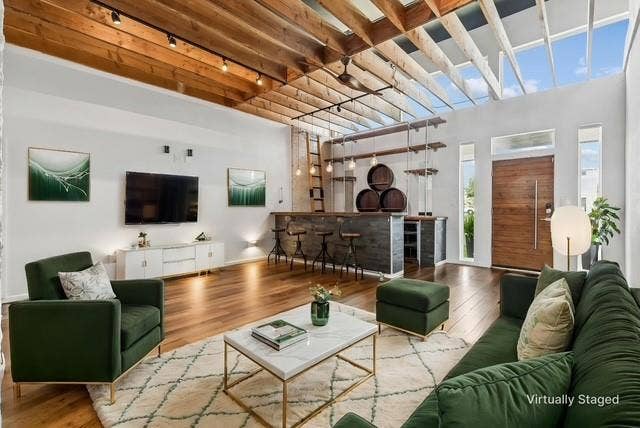 6360 Curtis Street, Plano, TX 75093 Very large living area with custom bar and wood slatted ceiling. Wood laminate flooring.