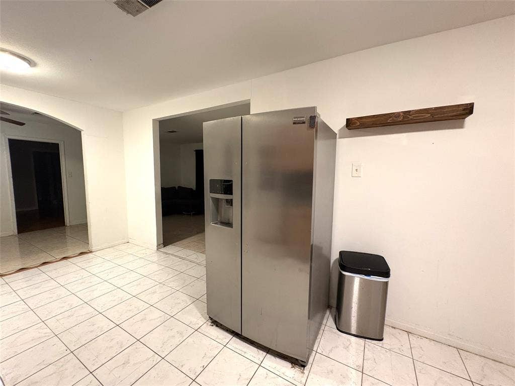 2829 Cecil Drive, Richland Hills, TX 76118 The kitchen features white tiled flooring and a stainless steel refrigerator