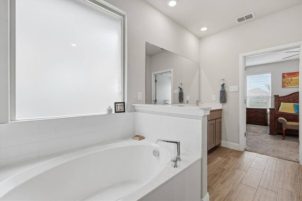 Master tub and tile flooring in ensuite off of Master bedroom
