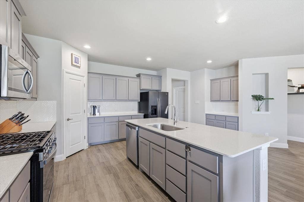 Gas cooking with white countertops and backsplash and look at the TONS of storage!